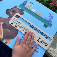 a child's hand is holding up a book that says i love you daddy