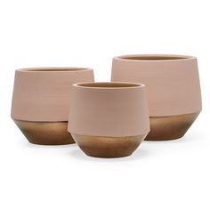 three pink vases sitting next to each other on a white surface with brown rims