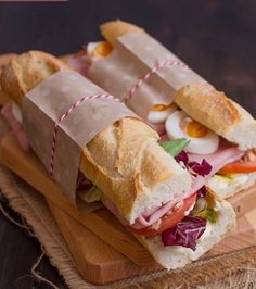 two sandwiches are sitting on a cutting board