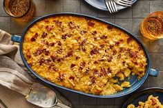 a casserole dish with meat and cheese in it on a table next to other dishes