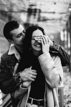 black and white photograph of a man kissing a woman's forehead on the subway platform