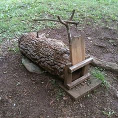 a wooden chair sitting on top of a pile of dirt next to a tree stump