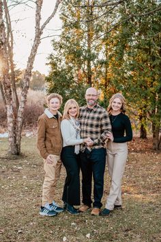 a family posing for a photo in front of some trees