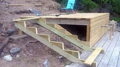 a wooden deck with steps leading up to a cave