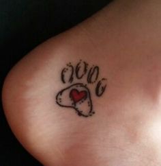 a dog paw with a heart tattoo on it's left side leg and the word love written in cursive writing