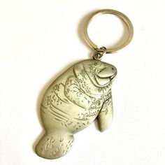 a metal keychain with a seal on it's side and an animal in the middle