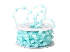 a spool of blue pom - poms sitting on top of a white surface