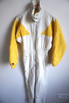 Sport suite details: * Colorful ELLESSE onepiece skiing suit  * Zipper closure on front * ribbon on waist * pockets on front * Ribbons on leg bottom * Condition: Perfect vintage condition Measurements, flat: Length: 62" / 154 cm Armpit to armpit: 25" / 62 cm Cuff to sleeve : 24 1/2" / 60 Label size: M (40) Feel free to message me with any questions 1960s Athletic Wear, Vintage Hooded Skiing Outerwear, Vintage Long Sleeve Windbreaker For Ski Season, Vintage Ski Suit, Yellow Vintage Long Sleeve Windbreaker, Overall Romper, Vintage Yellow Long Sleeve Windbreaker, Winter Jumpsuit, Tracksuit Tops