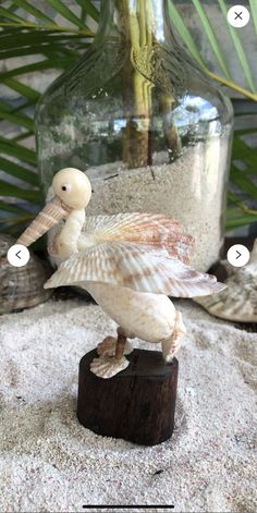 a seagull figurine sitting on top of a piece of driftwood