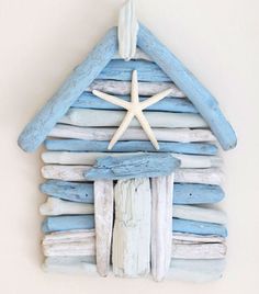 a house made out of driftwood with a starfish on the roof