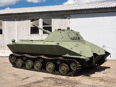 an army tank is parked in front of a building