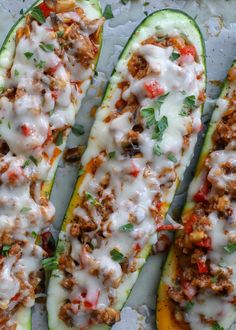 four stuffed zucchini boats with meat and cheese on top, ready to be eaten