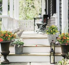 three flower pots on the front steps of a house