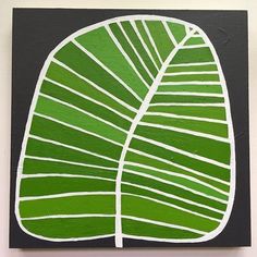 a green leaf is painted on a black and white background, with vertical lines in the center