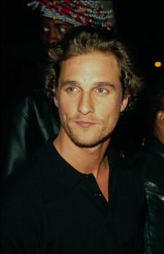 a close up of a person wearing a black shirt and looking at the camera with a serious look on his face