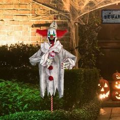 a creepy clown standing in front of some pumpkins