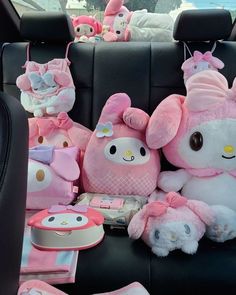 hello kitty stuffed animals sitting in the back seat of a car with other plush toys