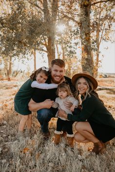 a family posing for a photo in the woods