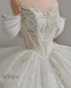 a white ball gown with beading on the shoulders