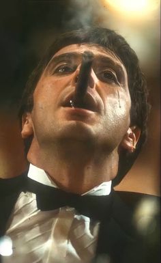 a man in a tuxedo looking up into the sky with his eyes closed