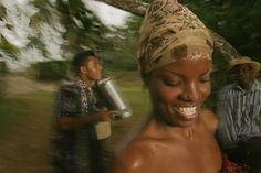 a woman with a bucket on her head and two men in the background walking together