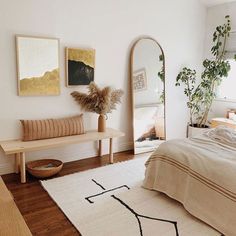 a bed room with a neatly made bed and a mirror on the wall next to it