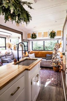 a living room filled with furniture and a christmas tree in front of a kitchen counter