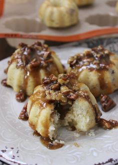 some kind of dessert on a plate with pecans in the middle and caramel sauce drizzled over it