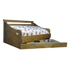 a wooden bed with two bowls on the bottom and one drawer open to allow dog food