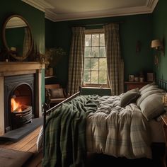 a bedroom with green walls and a bed in front of a fire place that is lit