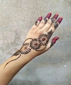 a woman's hand with hennap and flowers on the wrist, holding it up