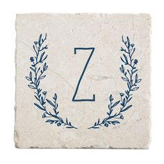 a stone coaster with the letter z on it and a blue wreath design in the middle