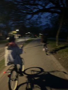 a person riding a bike down a street at night