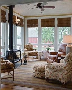 a living room filled with furniture and a fire place next to a window covered in blinds