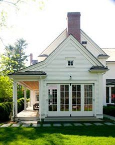 a white house sitting on top of a lush green field