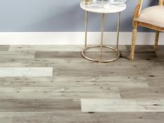 a white table sitting next to a chair on top of a hard wood floor