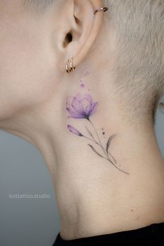 a woman's neck with a flower tattoo on it