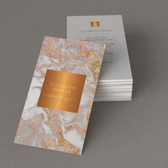 two business cards with gold foil on them, one is white and the other is pink marble