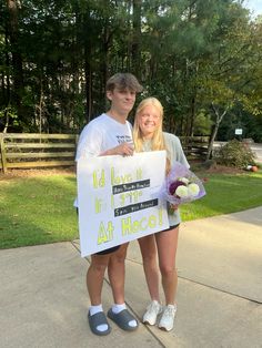 two people standing next to each other holding a sign that says i'd have it in the at hec