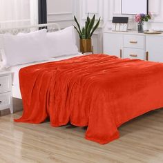 a bed with an orange blanket on top of it