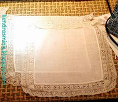 an old table cloth is sitting on top of a wicker mat with lace around it