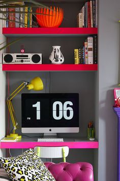 a computer monitor sitting on top of a pink shelf next to a purple chair and yellow lamp