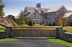 a large house with stone walls and a wooden gate