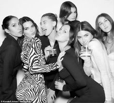 a group of women posing for the camera with one woman holding a wine glass in her hand