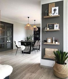 a dining room and kitchen area with wood flooring, gray walls and white furniture