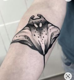 a black and white flower tattoo on the arm