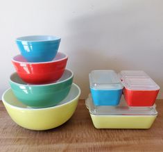 four bowls and one container are stacked on top of each other, with the lids down