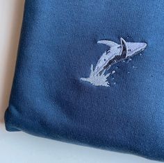 a blue pillow with a dolphin embroidered on it