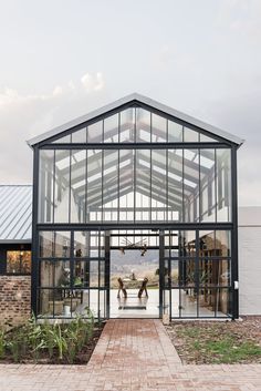 an open glass building with two people walking in the doorway