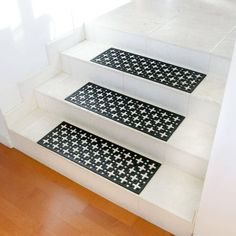 three black and white stair mats sitting on the side of a set of staircases